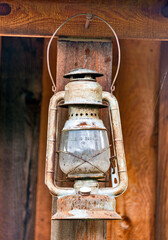 Old rusty oil-lamp under the summer wooden shed