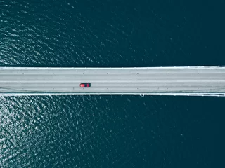 Fototapeten Aerial top view of bridge road with cars over blue lake © nblxer