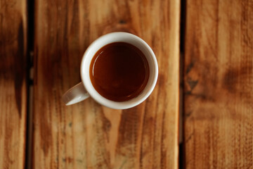 An espresso coffee mug standing on a wooden table. Barista coffee industry photography.