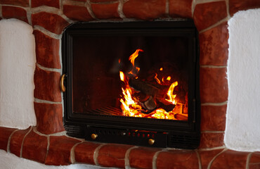 Fire in the fireplace at a mountain cabin. Cozy vibes in the mountains concept photo.