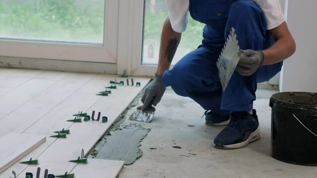 Installing ceramic floor tiles - measuring and cutting the pieces. Construction, renovation, repair apartment. Cuts tile. Tile cutting