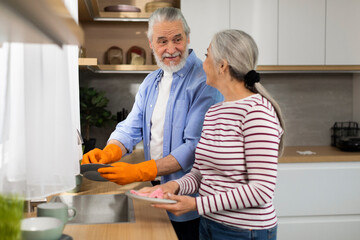 Helping Hand. Happy Senior Man Helping Wife With Dishes In Kitchen