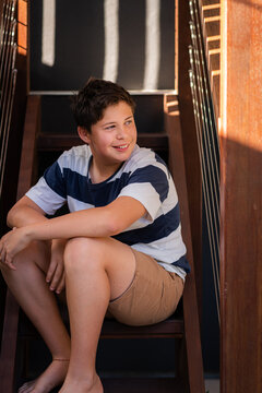 teen boy sitting on stairs at home