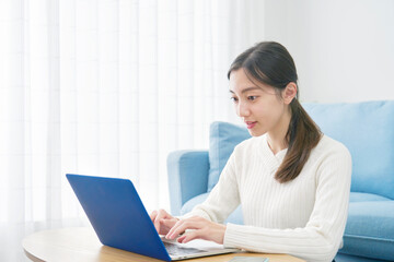 リビングでノートパソコンを使う女性