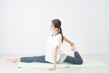 Fototapeta premium リビングで柔軟運動をする女性