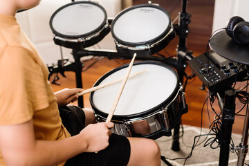 teen boy practising drums at home