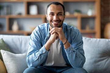 Portrait Of Happy Handsome Black Male Sitting On Couch In Home Interior
