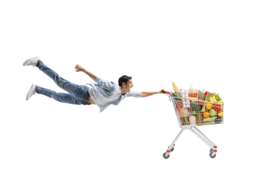 Foto op Aluminium Full length shot of a casual young man flying and holding a shopping cart with food © Ljupco Smokovski
