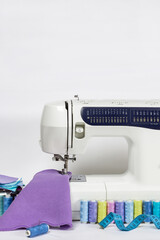 Sewing machine and threads on white desk with white background and copy space. Handicraft and hobby concept.
