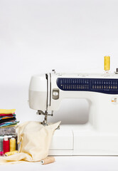 Sewing machine and colorful threads  on white  background with copy space. Sewing at home concept.