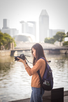 Woman taking a cityscape skyscrapers photo by using her camera.