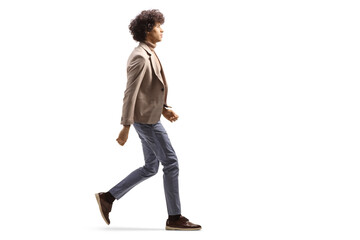 Full length profile shot of a tall man with a curly hair walking - obrazy, fototapety, plakaty