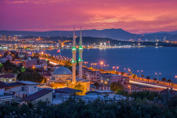 Colorful city by sunset, aliaga gulf with a colorful sunset clouds and lights