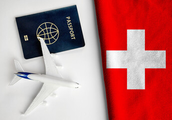 Flag of Switzerland with passport and toy airplane. Flight travel concept
