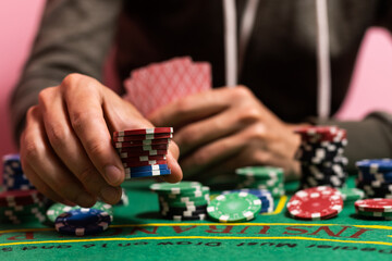 Casino, gambling and entertainment concept - stack of poker chips on a green table.