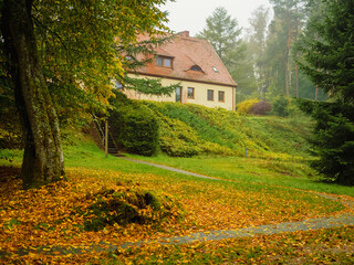 countryside farmhouse on a hill, view from backyard in a foggy moody autumn morning