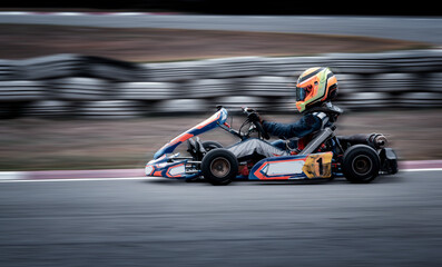 Go kart racing field, racer wearing safety uniform on competition tournament.	 - obrazy, fototapety, plakaty