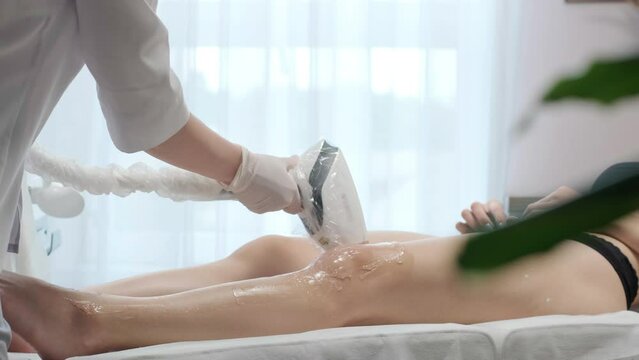 Laser epilation - hair removal procedure. Flash of diode laser hair removal, Beautician removes hair on beautiful female legs, Hair removal for smooth skin, laser procedure at beauty studio or clinic,