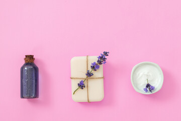 Lavender's spa products with dried lavender flowers on pink background.
