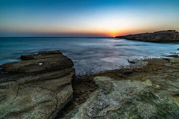 Fototapeta na wymiar Flat rocks beach in sunset Nachsholim Israel