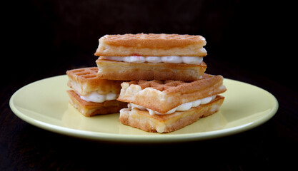 Viennese ruddy waffles lie on a yellow plate.