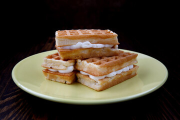 Viennese ruddy waffles lie on a yellow plate.