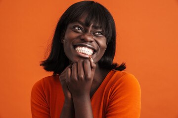 Close up portrait of smiling african lady touching chin isolated