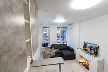 Modern studio flat with small kitchen, sofa.