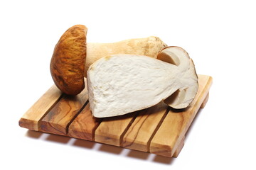 Boletus edulis half on cutting board isolated on white  