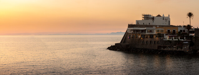 promontory with church of soccorso ischia at sunset