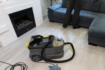 Hand cleaning a sofa with a steam cleaner, Home cleaning concept