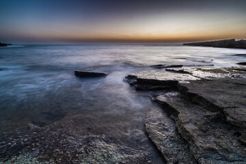 Fototapeta premium sunset over Laminations of Flat rocks in the beach nachsholim Israel