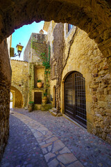 Fototapeta premium Medieval alley with stone houses and arches in the picturesque town of Pals, Girona, Spain.