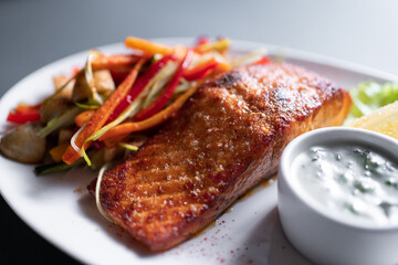 fresh red grilled salmon steak with vegetable salad and sweet sauce, closeup