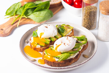 Two avocado open sandwiches with egg. Keto and diet concept. Healthy toast food for breakfast.