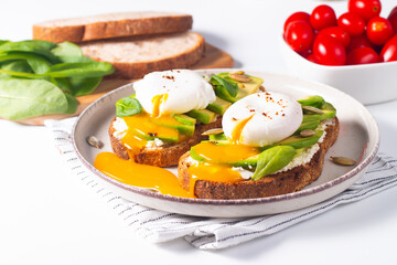 Two avocado open sandwiches with egg. Keto and diet concept. Healthy toast food for breakfast.