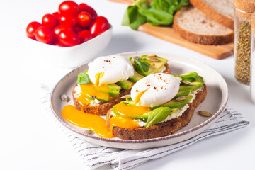 Two avocado open sandwiches with egg. Keto and diet concept. Healthy toast food for breakfast.