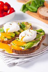 Two avocado open sandwiches with egg. Keto and diet concept. Healthy toast food for breakfast.