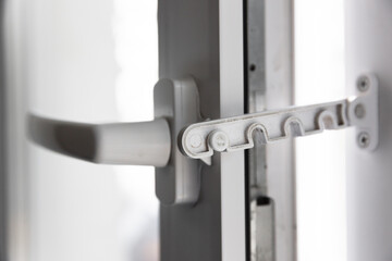 Close-up shot of a double-glazed plastic door frame, one-way balcony window handle,PVC window latch fixes the sash.House door and window repair concept