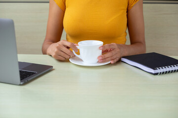 Crop freelancer enjoying hot drink in cafe 