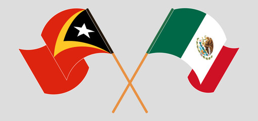 Crossed and waving flags of East Timor and Mexico