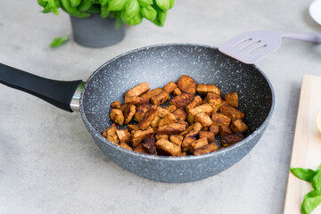 Roasted Tempeh or Tempeh, made of fermented soybean seeds. Fried cubed Tempeh in the pan. Soya protein. Plant based meat. Healthy Cooking and eating. Go vegan. Selective focus, copy space