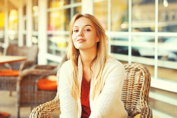 Portrait of beautiful young woman sitting and waiting in the cafe