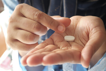 Close up of women hand taking pills 