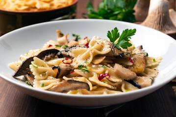 Piatto di farfalle con funghi, peperoncino e prezzemolo, pasta italiana 