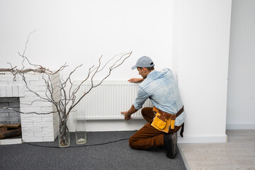 A man changes the heating in the house, radiators. The concept of modern heating, replacement of...