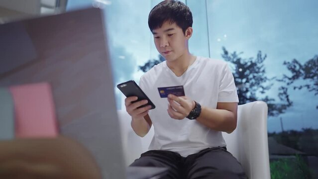 Asian man use credit card to make online transactions, shopping online, filling credit card ccv code, online digital wallet security, cyber hacked, use smartphone for travel booking and reservation