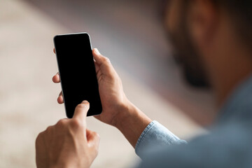 Unrecognizable Black Man Using Smartphone With Blank Indoors, Mockup