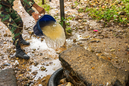 Military Dressed In Uniform And Throwing A Bucket Of Dirty Water In Nicaragua