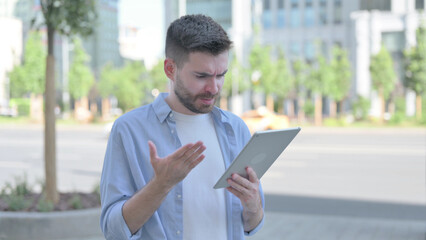 Upset Young Man Reacting to Loss on Tablet Outdoor